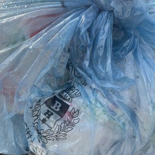 Un sacco azzurro in un cestino per strada