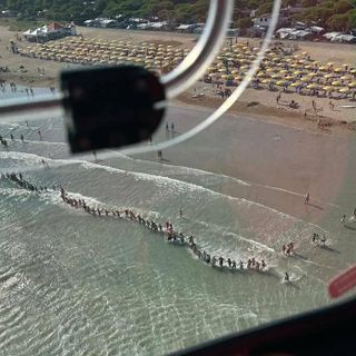 La catena umana dei bagnanti impegnati nelle ricerche del bambino a Jesolo