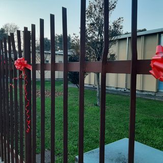 Fiocchi rossi sul cancello della scuola Toscanini di Legnano