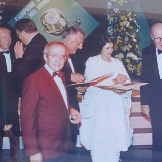 Lucio Piccoli, in giacca bordeaux, con Carla Fracci