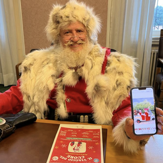 Babbo Natale Gerardo Giovi mostra sorridente la slitta calesse con la quale percorrerà l'itinerario a forma di cuore