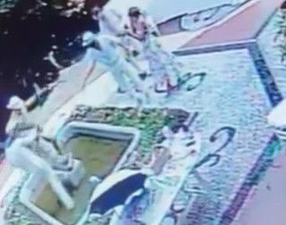 A sinistra i due ragazzi perdono l'equilibrio trascinandosi a terra la statua