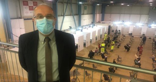 Il dottor Marino Dell'Acqua al centro vaccinale. Nella foto sotto con alcuni dei medici che si sono resi disponibili a MalpensaFiere