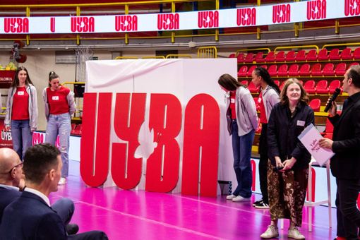 Il nuovo logo Uyba. Nella foto sotto: la sciarpa biancorossa con il nuovo logo esibita con orgoglio da tutti gli sponsor presenti