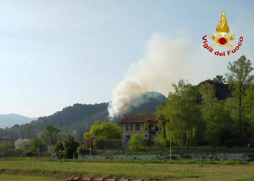 Le fiamme sulla collina ad Angera (foto: Serena Riganti via NaturalMeteo). Nella gallery in basso: le immagini dell'incendio nelle foto dei vigili del fuoco, un'altro scatto delle fiamme viste da Taino (foto Yari Frosi via NaturalMeteo) e il rogo visto da Arona