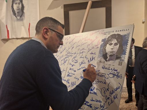 Francesco Attolini firma una maxi cartolina con la riproduzione del francobollo dedicato a Sergio Ramelli Francesco Attolini firma una maxi cartolina con la riproduzione del francobollo dedicato a Sergio Ramelli