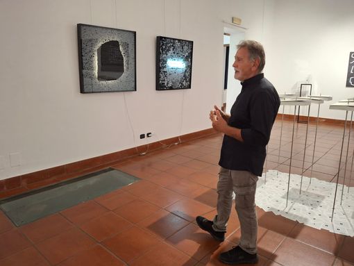 Claudio Benzoni davanti a una sua citazione della Stele di Rosetta