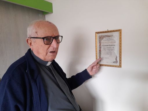 Monsignor Livetti indica l'attestato del suo Battesimo Monsignor Livetti indica l'attestato del suo Battesimo