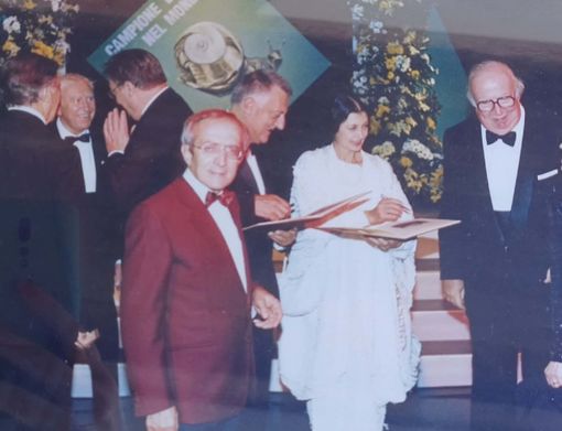 Lucio Piccoli, in giacca bordeaux, con Carla Fracci