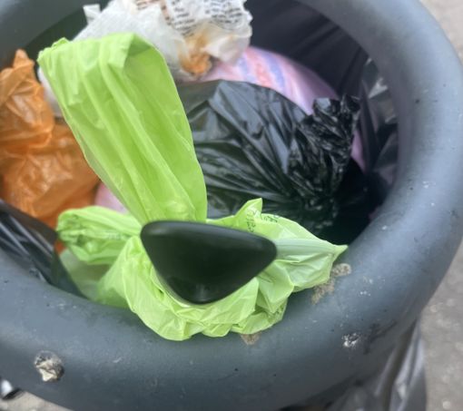 Un cestino dove spunta il manico di una padella, non proprio rifiuto da passeggio Un cestino dove spunta il manico di una padella, non proprio rifiuto da passeggio