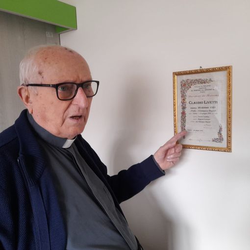 Monsignor Livetti indica l'attestato del suo Battesimo