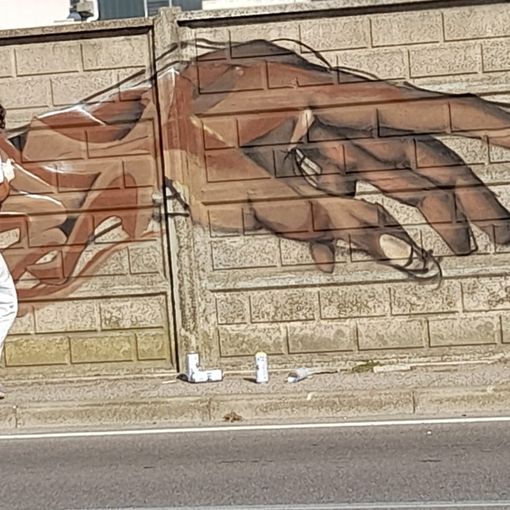 Giovani artisti all'opera in via Menotti (anche nelle immagini in fondo all'articolo con il gazebo allestito dall'associazione Comitato di Quartiere)