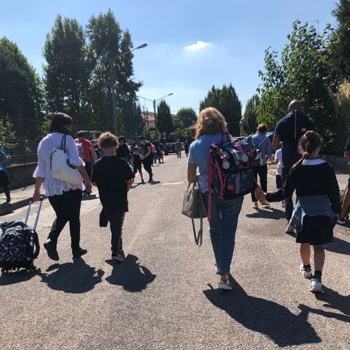 Genitori e bambini camminano in sicurezza sulle strade che portano a scuola. Effetto delle &quot;Zone scolastiche&quot;
