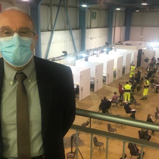 Il dottor Marino Dell'Acqua al centro vaccinale. Nella foto sotto con alcuni dei medici che si sono resi disponibili a MalpensaFiere
