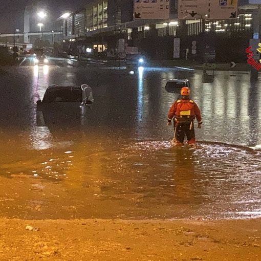 In alto: l'evacuazione con i gommoni (da un video amatoriale). In basso: alcune delle auto sommerse con i vigili del fuoco al lavoro