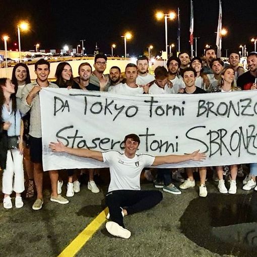 FOTO. &quot;Da Tokyo torni bronzo, stasera torni sbronzo&quot;: a Linate l'abbraccio di famiglia e amici all'uomo rana Martinenghi