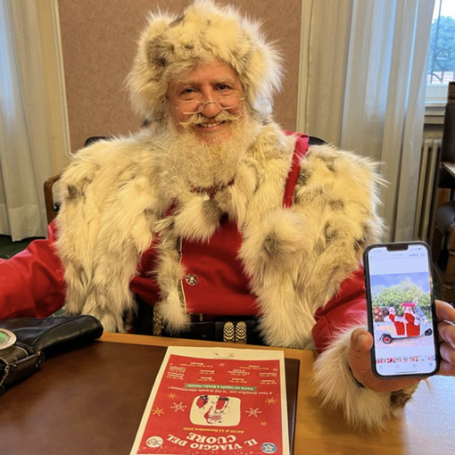 Babbo Natale Gerardo Giovi mostra sorridente la slitta calesse con la quale percorrerà l'itinerario a forma di cuore