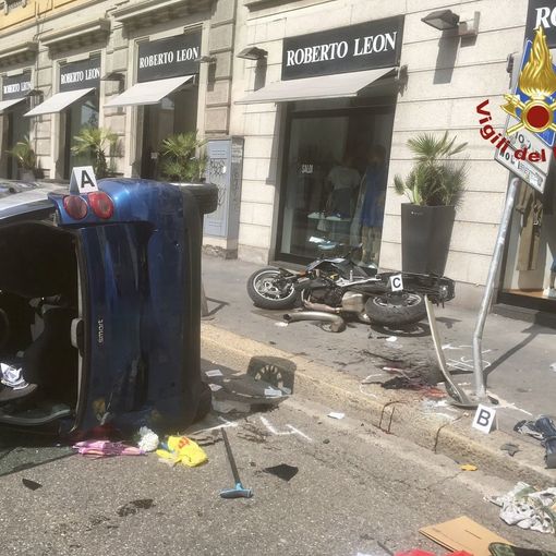 FOTO. Auto si ribalta, abbatte un palo e colpisce una ciclista: tre feriti a Milano, grave una giovane
