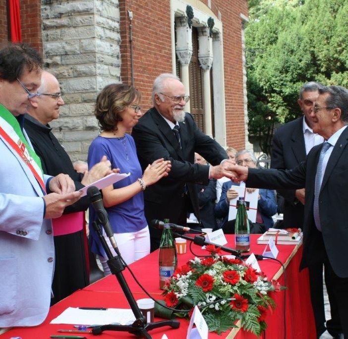 Pietro Magistrelli ritira la civica benemerenza nel 2014 (foto Città di Busto Arsizio). Sotto con l'allora assessore ai Servizi sociali Miriam Arabini