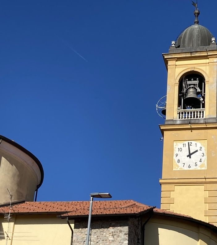 La torre campanaria della chiesa parrocchiale Santa Maria Assunta di Gorla Maggiore. Sotto: il parroco, don Valentino Viganò