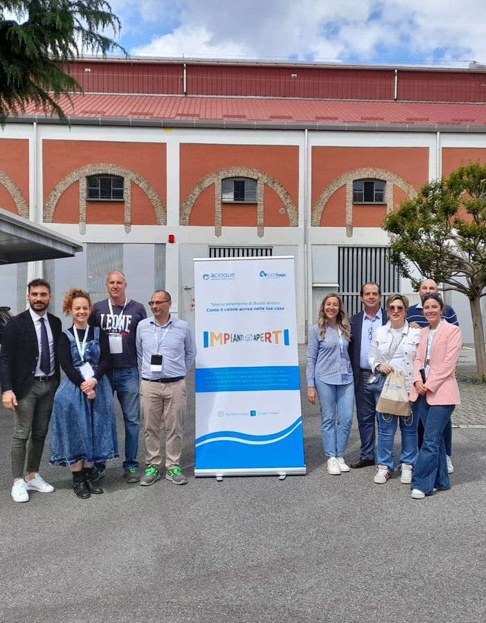 Alcuni dipendenti impegnati nell'open day, con l'ad Tugnoli, primo da sinistra, e il presidente Montani, nel gruppetto alla destra del roll-up