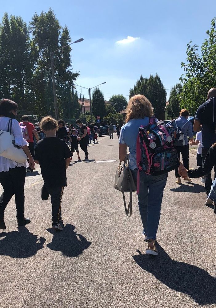 Genitori e bambini camminano in sicurezza sulle strade che portano a scuola. Effetto delle &quot;Zone scolastiche&quot;