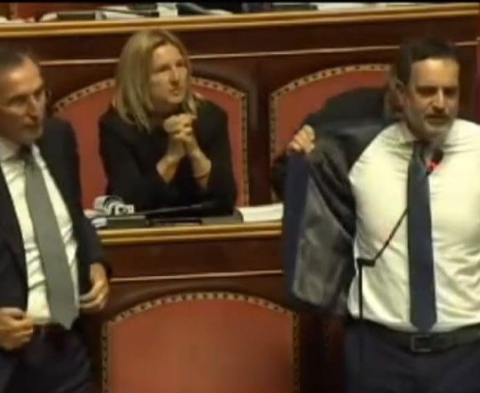 Il senatore Alfieri si toglie la giacca in aula, guidando la protesta dell'opposizione (immagini Rai)