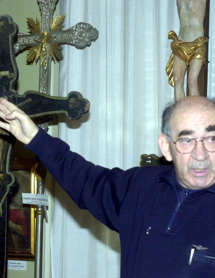 Don Luigi Brambillasca fotografato da Daniele Belosio mentre indica la Croce nella sua chiesa
