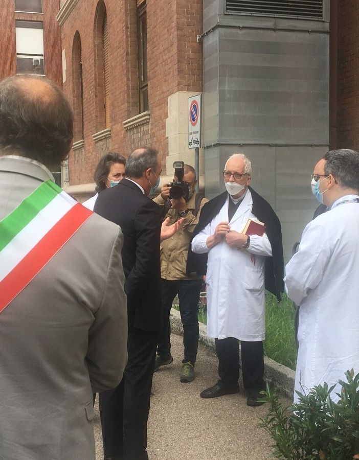 Don Peppino Colombo durante una visita dell'allora assessore regionale Gallera in ospedale