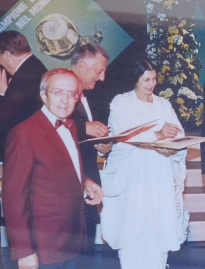 Lucio Piccoli, in giacca bordeaux, con Carla Fracci