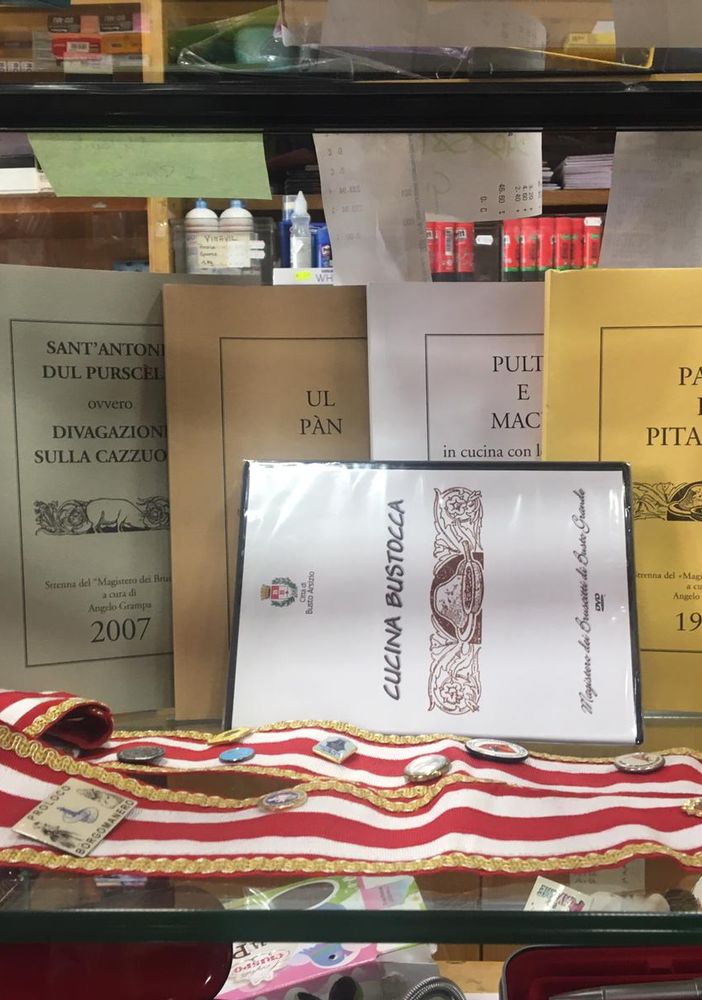 Una vetrina con le pubblicazioni e i simboli del Magistero dei Bruscitti nella cartoleria Tagliabue