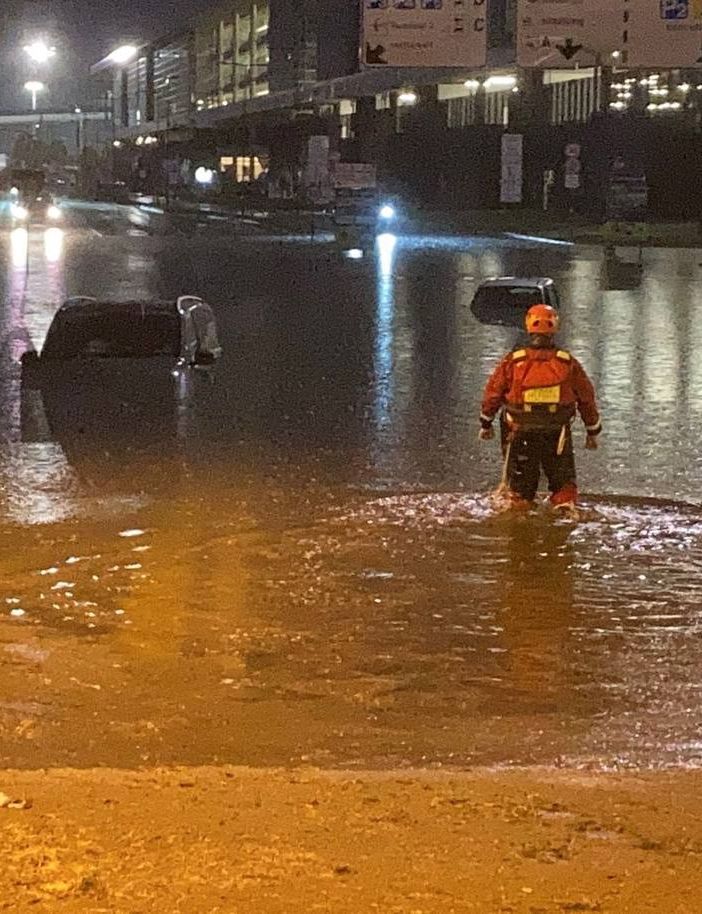 In alto: l'evacuazione con i gommoni (da un video amatoriale). In basso: alcune delle auto sommerse con i vigili del fuoco al lavoro