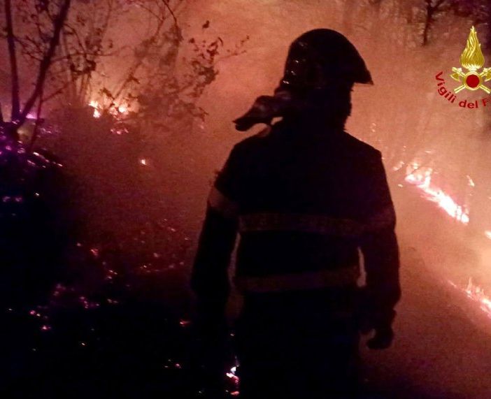 Un vigile del fuoco al lavoro stanotte per fermare l'incendio di Angera
