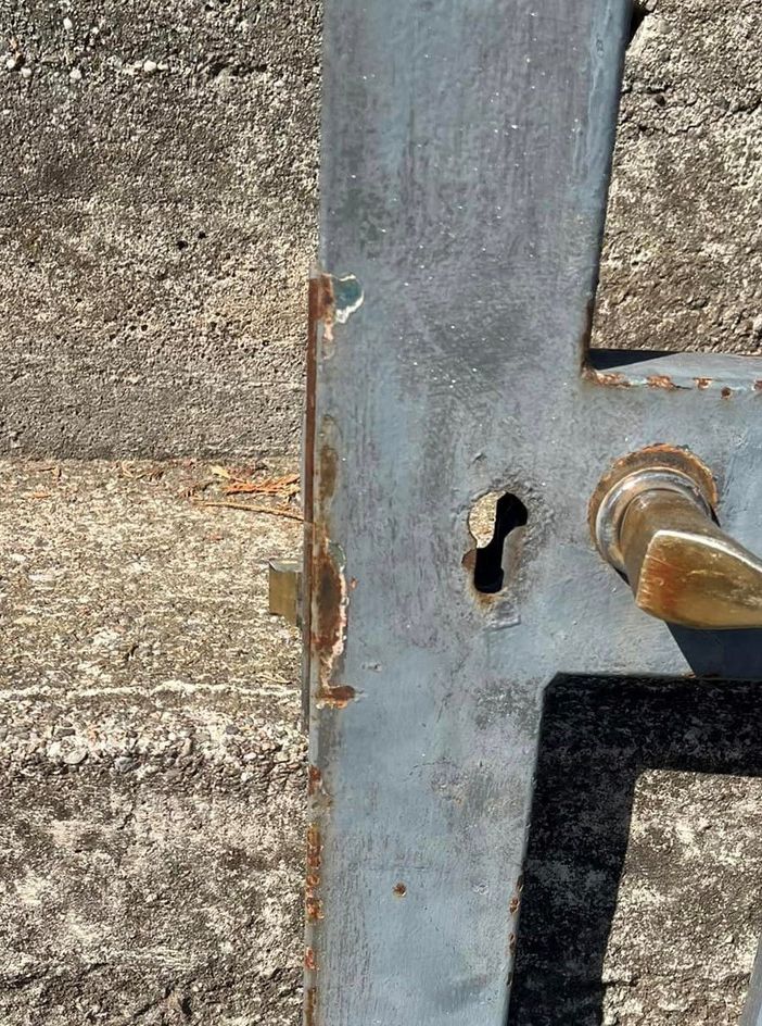 La serratura del cancello della scuola danneggiato in una foto dalla pagina Facebook del sindaco