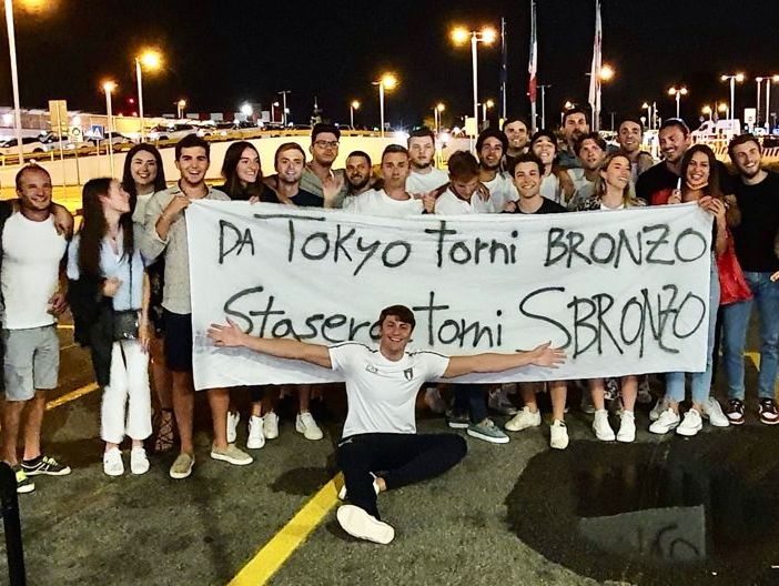 FOTO. &quot;Da Tokyo torni bronzo, stasera torni sbronzo&quot;: a Linate l'abbraccio di famiglia e amici all'uomo rana Martinenghi