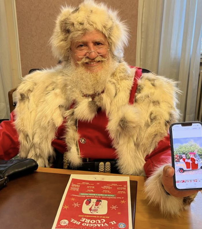 Babbo Natale Gerardo Giovi mostra sorridente la slitta calesse con la quale percorrerà l'itinerario a forma di cuore