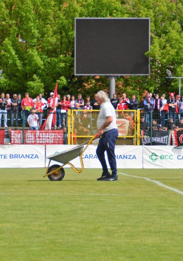 La surreale immagine di un addetto della Folgore Caratese con carriola in mezzo al campo prima della finale playout, mentre erano in corso gli scavi sulla linea di porta per alzare la traversa