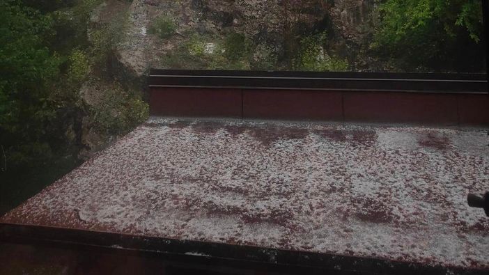 La grandine accumulata su una tettoia al Campo dei Fiori (foto da Olgher) e, sotto nella gallery, i chicchi raccolti da Ester a Melide (foto via NaturalMeteo) e il fiume bianco che ha invaso Verbania