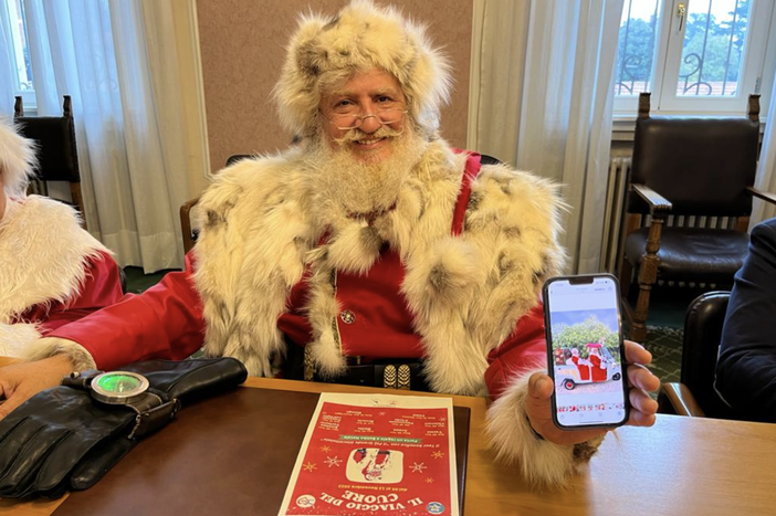 Babbo Natale Gerardo Giovi mostra sorridente la slitta calesse con la quale percorrerà l'itinerario a forma di cuore