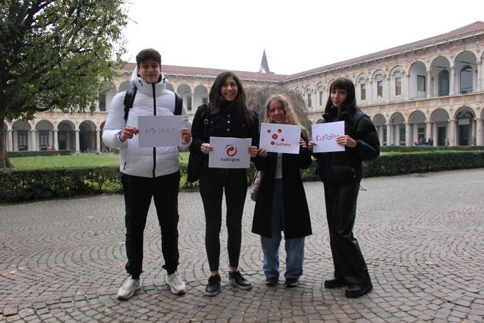 Aurora Soragna, studentessa di quarta all’Istituto tecnico Olga Fiorini di Grafica e Comunicazione, mostra il logo vincitore del concorso CutToPro e festeggia con alcuni compagni di classe che hanno partecipato all’iniziativa e con la giuria del premio indetto dall’Università Statale di Milano con il finanziamento di Fondazione Cariplo