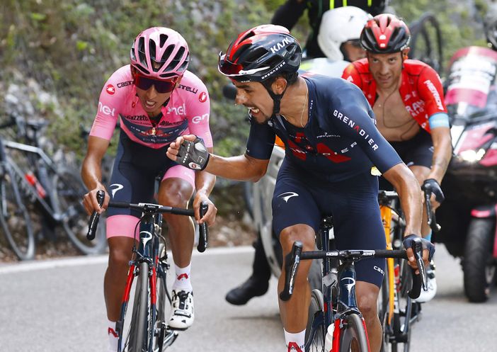 Martinez in versione angelo custode sostiene la maglia rosa Bernal sulla salita finale: un'immagine simbolo di questo Giro e del ciclismo