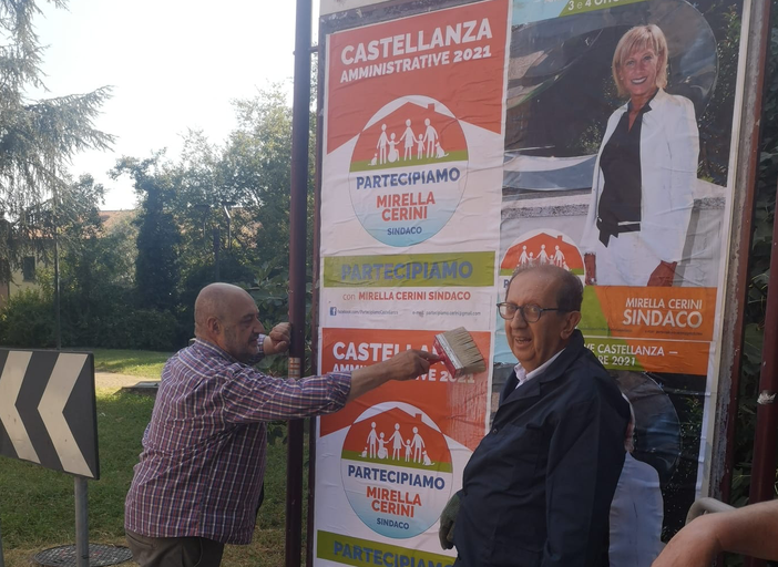 Subito al lavoro per rimpiazzare i manifesti imbrattati a Castellanza (sotto)