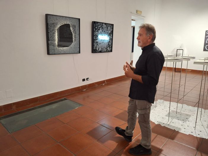 Claudio Benzoni davanti a una sua citazione della Stele di Rosetta