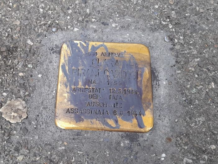 La pietra d'inciampo dedicata a Clara Pirani Cardosi. In fondo all'articolo, la svastica vicino alla pietra dedicata a Vittorio Arconti