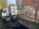 Un camion dei rifiuti in bilico rischia di cadere nell'Olona