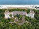 L'impressionante gigante addormentato e ormai a pezzi della Colonia Varese di Milano Marittima visto dal drone e separato solo dai pini dalla folla agostana sulle spiagge (foto Alessandro Umberto Galbiati)