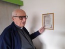 Monsignor Livetti indica l'attestato del suo Battesimo