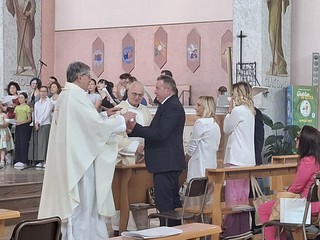 Lo scambio del segno di pace, con i sacerdoti e i familiari, durante la messa