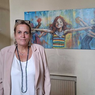 Paola Reguzzoni davanti all'opera che sintetizza lo spirito dell'affido familiare