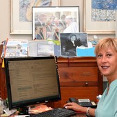 Mirella Cerini alla sua scrivania (sul muro si vede tra le foto quella con il Papa), da tifosa neroverde e la sera del videomapping natalizio